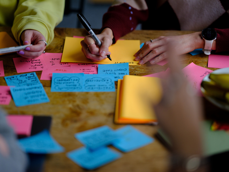 people sat round a table using sticky notes