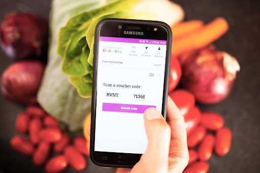 A mobile phone showing a Rose Voucher that families on low incomes can use to buy fresh fruit and vegetables.