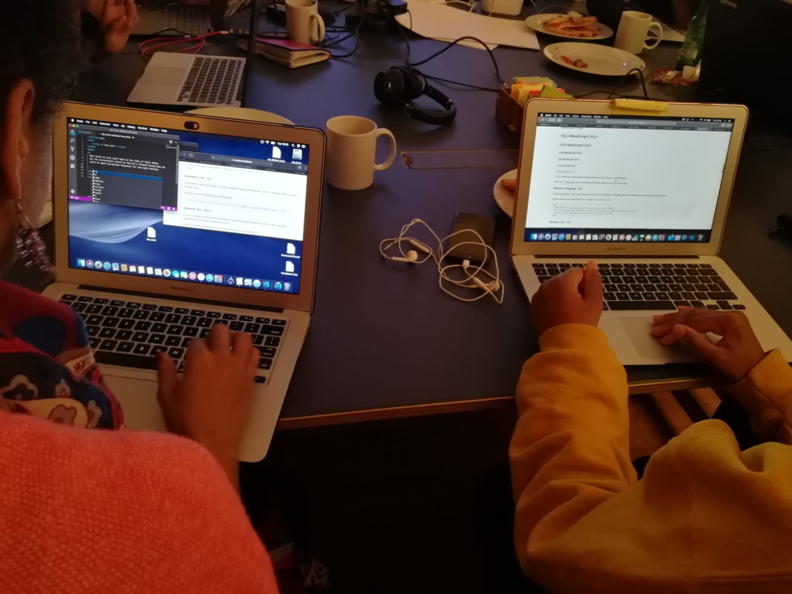 two people working on their laptops at coding event