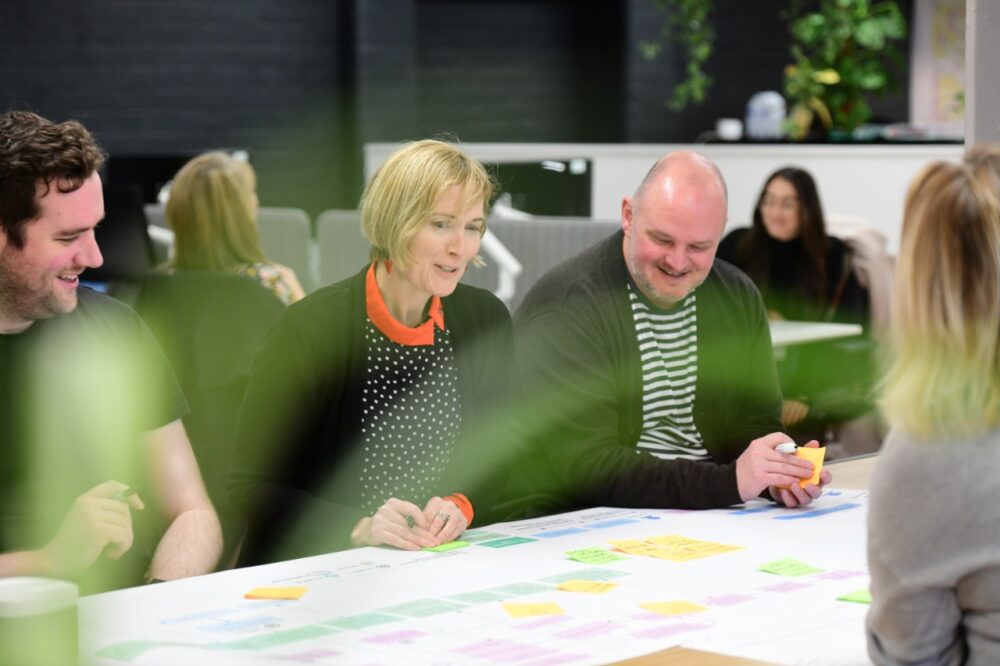 People working on a diagram sitting at a table