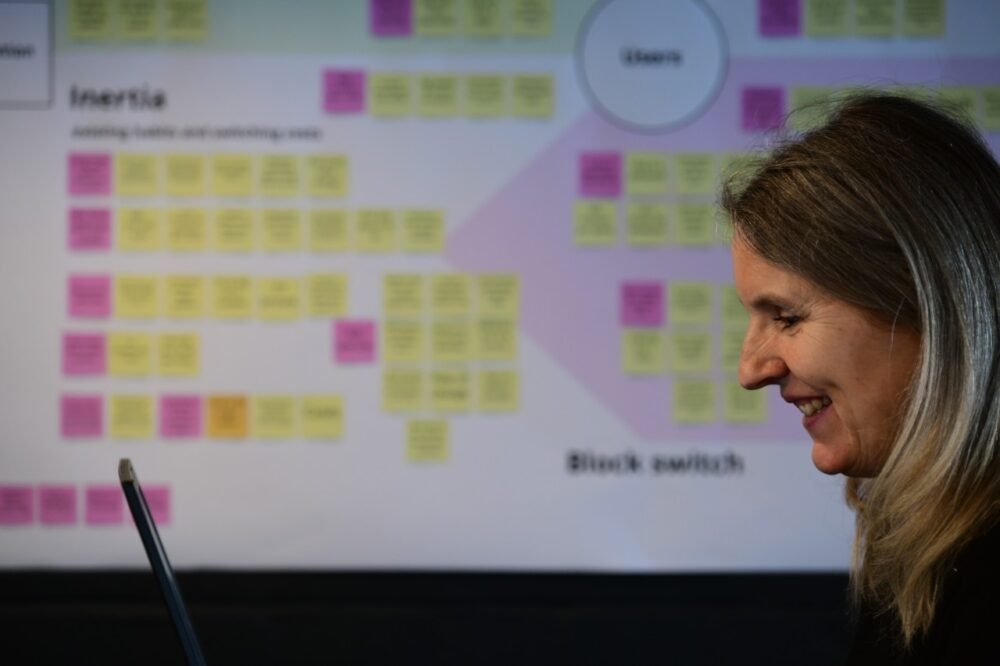 A person working on a laptop in front of a diagram on a wall