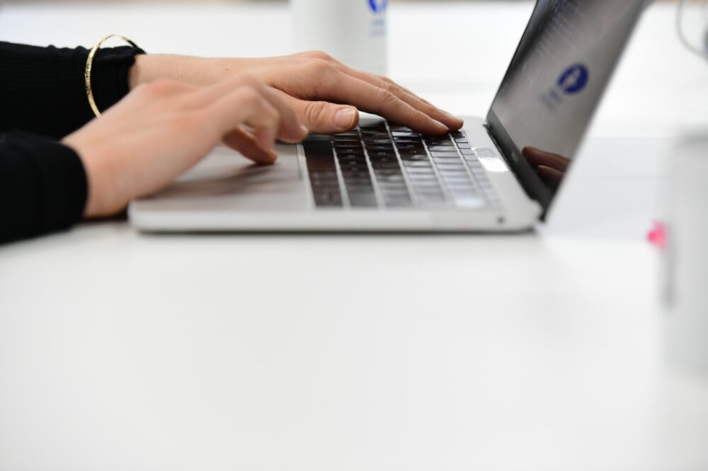 A close up of a person's hands using a laptop
