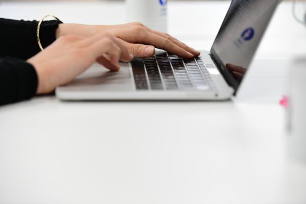 A close up of a person's hands using a laptop