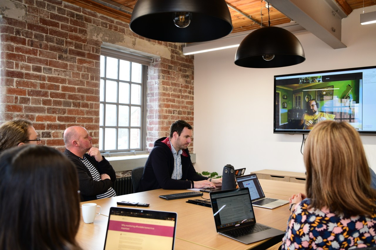 People in a meeting with a remote person on a screen