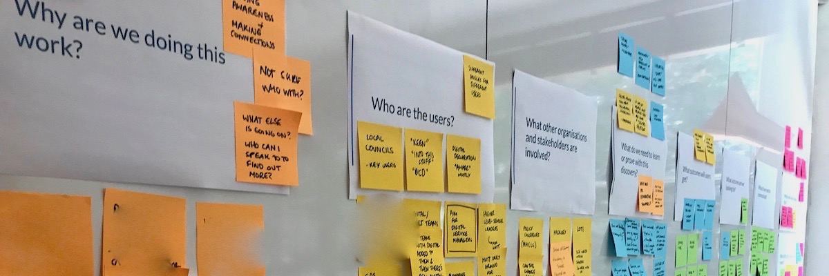 Photo of the questions and sticky notes answers on a wall.